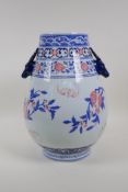 A blue and white porcelain vase with two stag mask handles, decorated with red bats and