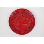 A Chinese cinnabar lacquer style dish with riverside landscape decoration, 15cm diameter