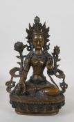 A Sino Tibetan bronze figure of a goddess seated on a lotus throne, 22cm high