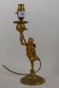 A brass table lamp in the form of a putto bearing a torchere, 24cm high