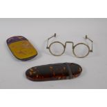 An antique tortoise shell and white metal spectacle case, and a pair of Oriental folding