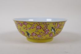 A polychrome porcelain bowl with bird and prunus blossom decoration on a yellow ground, Chinese