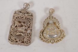 A Chinese white metal pendant with pierced dragon decoration, and another similar with Buddha