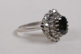 An 18ct white gold dress ring set with a central sapphire encircled by diamonds, approx 3cts, size