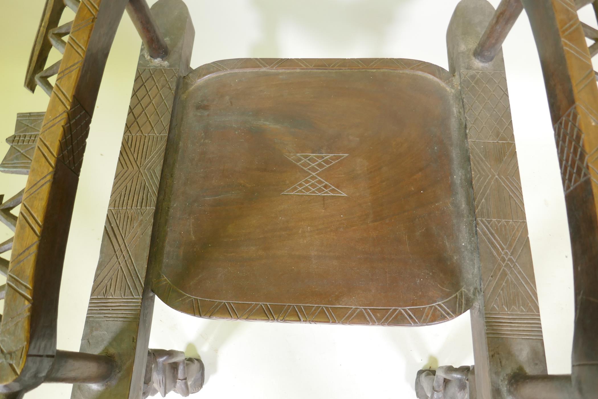 An African carved wood throne chair decorated with masks and geometric patterns, the legs carved - Image 4 of 4