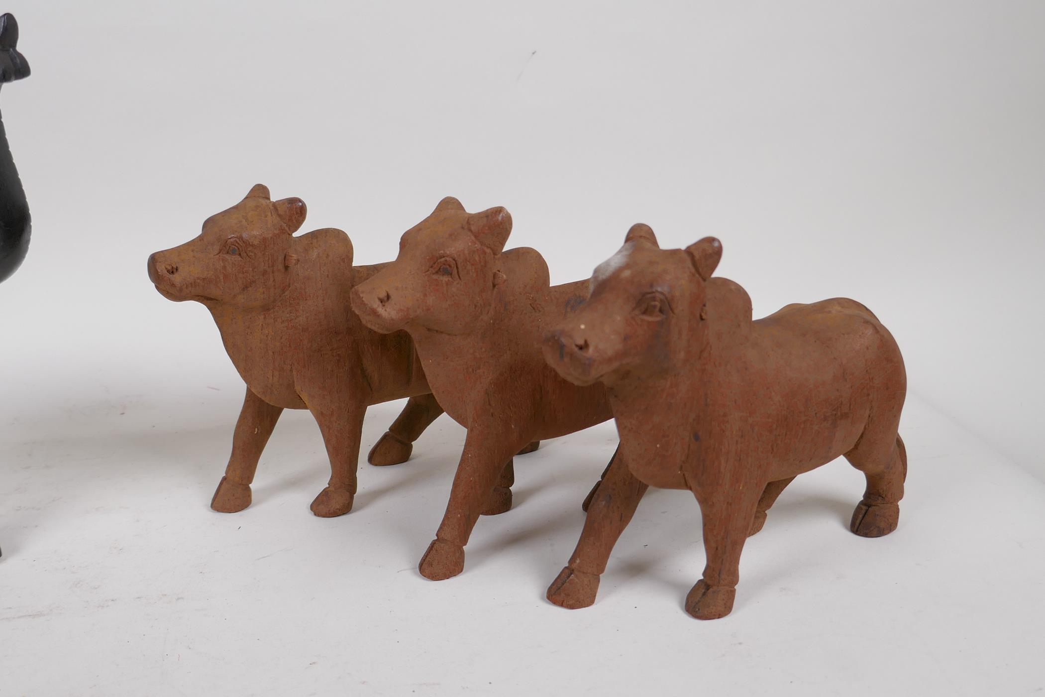 A collection of Indian carved wood animals including a pair of ebony elephants, cows etc, largest - Image 4 of 5