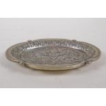 A Chinese white metal trinket dish of lobed form, with raised dragon and phoenix decoration,