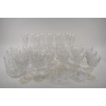 A suite of crystal drinking glasses to include Champagne flutes, wine and sherry stem glasses,