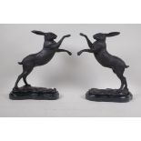 A pair of bronze figures of boxing hares, mounted on marble bases, 30cm high