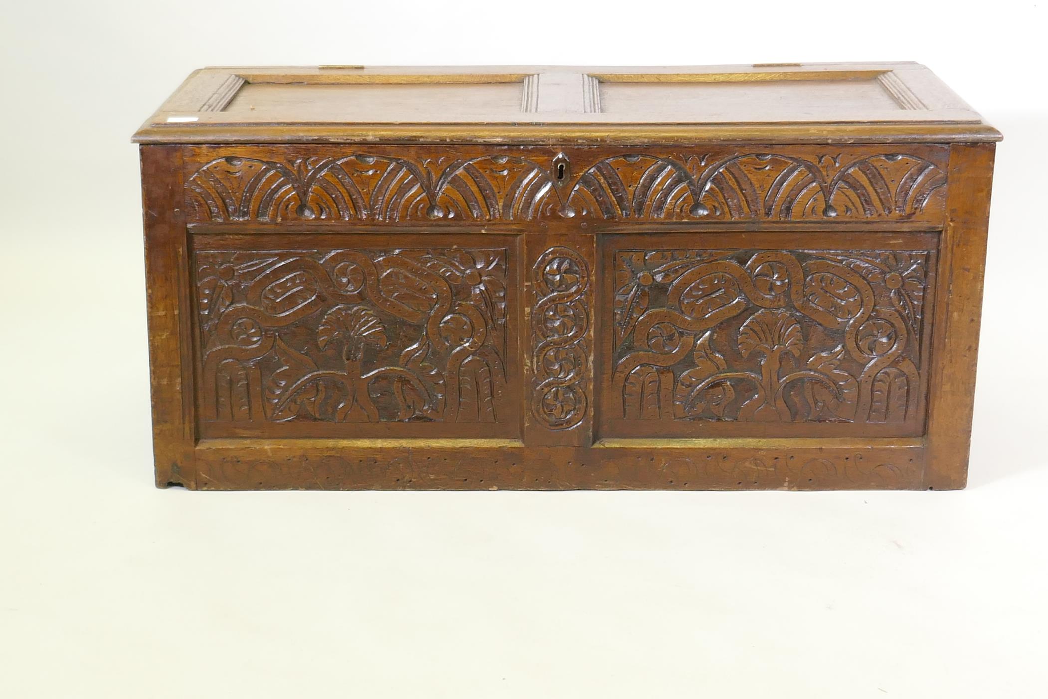 An C18th oak coffer with two carved panels and frieze and panelled top, 116 x 49 x 52cm