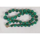 A string of graduated malachite beads, with 9ct gold clasp