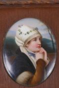 A small oval Bavarian porcelain portrait plaque painted with a country girl, 8cm x 6.5cm, in a