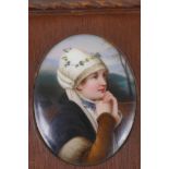 A small oval Bavarian porcelain portrait plaque painted with a country girl, 8cm x 6.5cm, in a