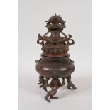 A Tibetan gilt bronze censer and cover raised on tripod mythical creature feet, with knop in the