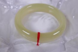 A Chinese cabbage green hardstone bangle, 8cm diameter