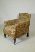 A late Victorian armchair with original printed linen covers, raised on square tapering supports