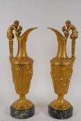 A pair of ormolu ewers with satyr handles and raised Bacchanalian frieze, mounted on marble bases