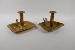 A pair of Georgian brass ejector chamber sticks with rectangular  drip trays, AF, 18cm x 17cm,