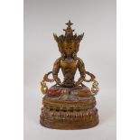 A Tibetan gilt bronze figure of a multi faceted Buddha seated on a lotus throne, 39cm high