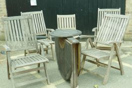 A set of four teak reclining garden armchairs, a single chair and a drop leaf table with lazy susan,