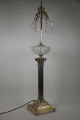 A Victorian silver plated Corinthian column table lamp with glass reservoir, converted to