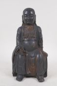 An oriental bronze figure of Buddha, with black patination and traces of gilt, 24 cm high
