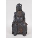 An oriental bronze figure of Buddha, with black patination and traces of gilt, 24 cm high