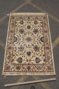 An ivory ground Kashmir carpet with all over floral pattern and lotus flower decoration, signed,