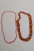 A string of vintage amber beads (51g) and a coral beaded necklace, longest 96cm