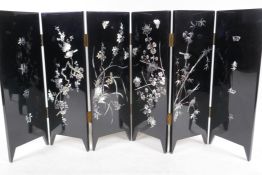 A Chinese six fold lacquered table screen with inlaid mother of pearl decoration, the reverse