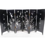 A Chinese six fold lacquered table screen with inlaid mother of pearl decoration, the reverse