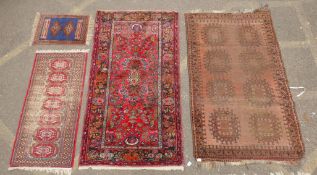 A Turkish rust ground wool rug with a medallion design, a worn red ground Bokhara runner, a deep