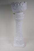 A German white glazed pottery jardiniere on stand with embossed flower and vine decoration, 67cm