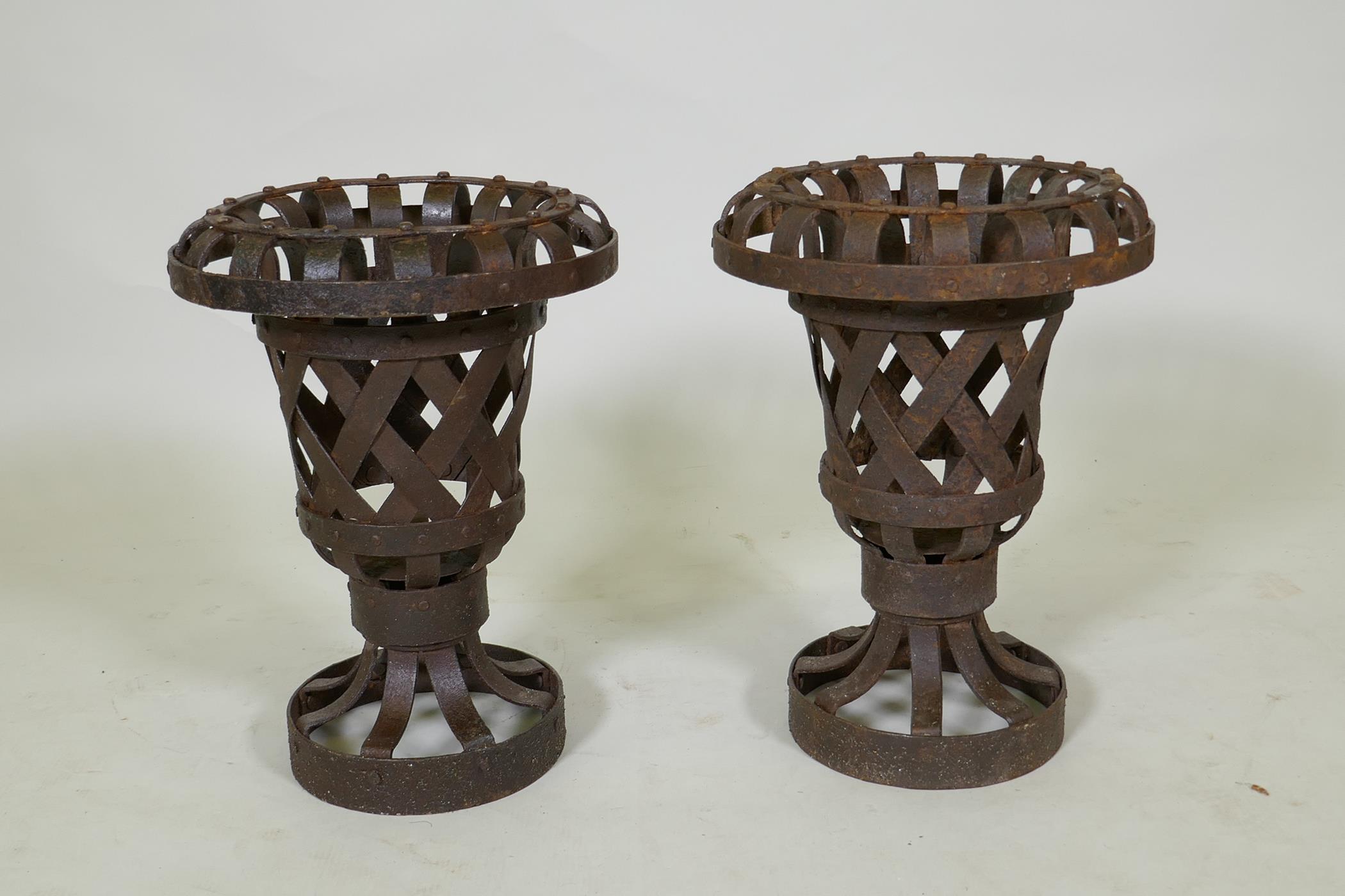 A pair of iron openwork garden pedestal urns, 37cm high