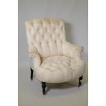 A Victorian armchair, raised on turned and ebonised supports, 89cm high