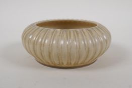 A Chinese song style cream glazed porcelain dish with ribbed exterior, Qianlong mark to base, 14cm