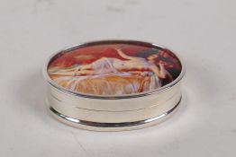 A sterling silver oval pill box set with an enamel plaque depicting a female nude, 4cm x 2.5cm