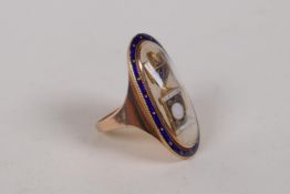 A Georgian high carat rose gold mourning ring with enamelled details, engraved to back