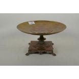 An antique copper and brass tazza, the inset plaque with raised classical design, 27cm diameter,