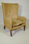 A Victorian barrel back wing armchair, raised on square tapering supports