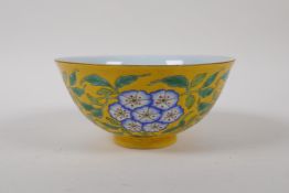 A polychrome porcelain rice bowl with floral decoration on a yellow ground, Chinese 4 character mark