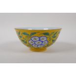 A polychrome porcelain rice bowl with floral decoration on a yellow ground, Chinese 4 character mark