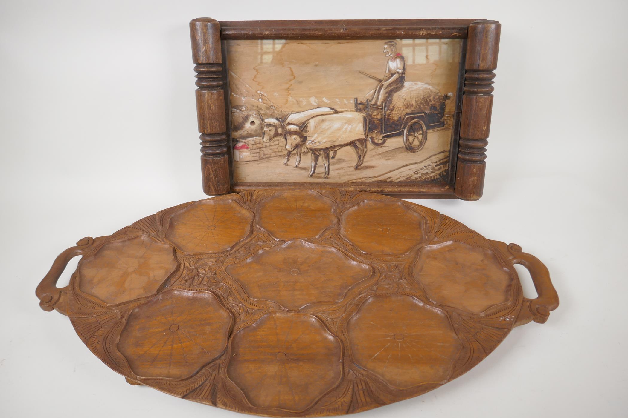 A vintage European carved wooden tray decorated with a naive scene of a man driving a bullock