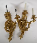 A pair of gilt metal Rococo style twin branch electric wall sconces, 16" high