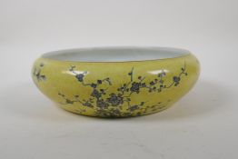 A Chinese yellow glazed porcelain dish with rolled rim, with black and white floral decoration, mark
