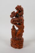 A Chinese lacquered boxwood carving of Lohan beneath a cypress tree, 22cm high