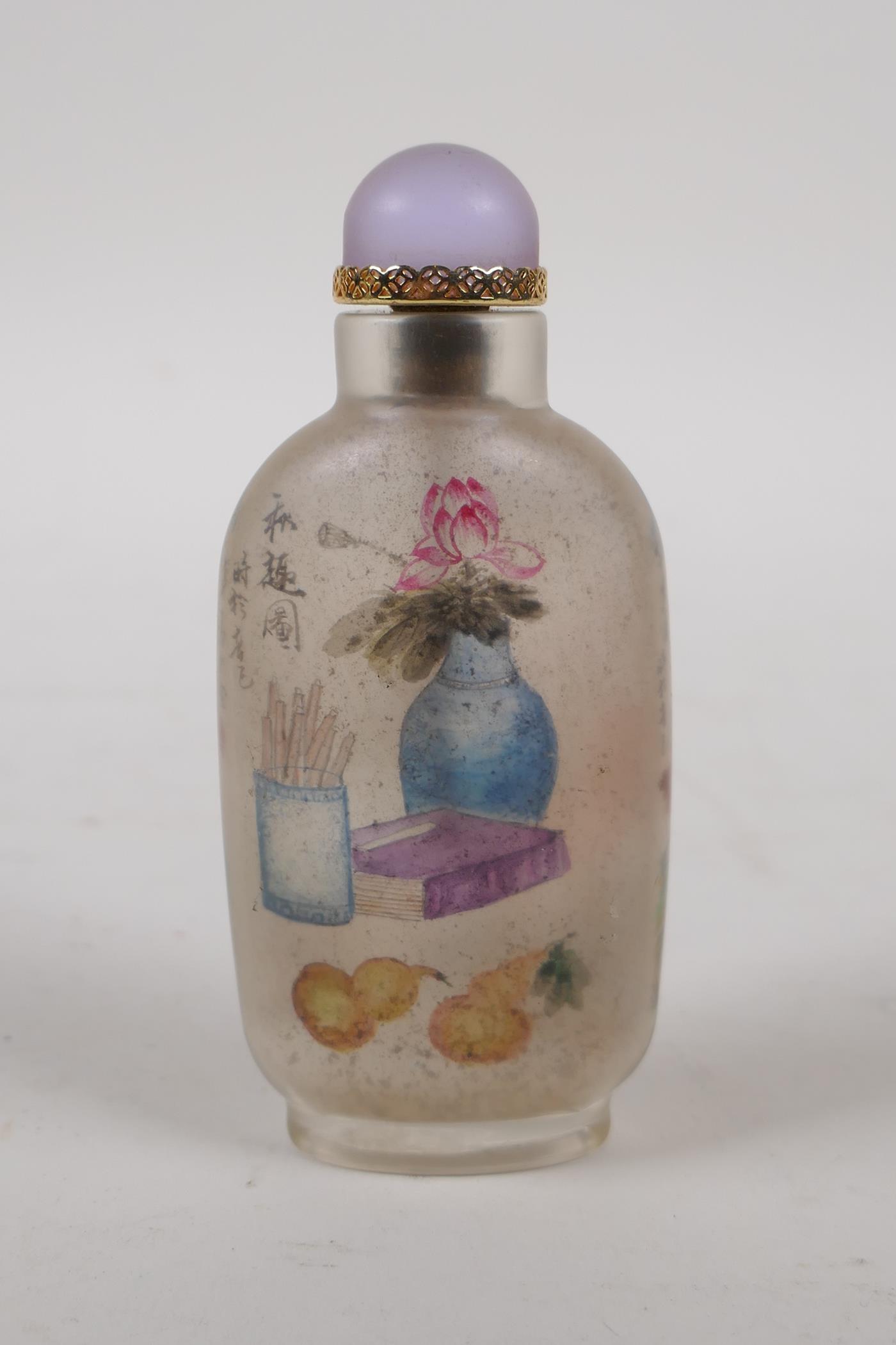 A Chinese reverse decorated glass snuff bottle depicting a riverside landscape and objects of - Image 2 of 2