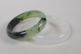 A Chinese bi-colour hardstone bangle and another, 8cm diameter