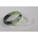 A Chinese bi-colour hardstone bangle and another, 8cm diameter