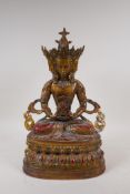 A Tibetan gilt bronze figure of a multi faceted Buddha seated on a lotus throne, 39cm high
